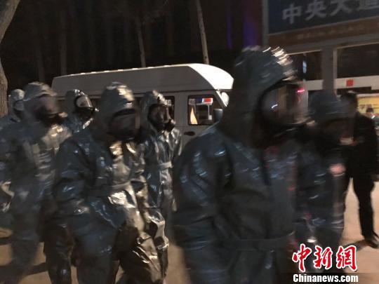 十几名身着防护服的人员头戴面具进入事发地。　胡健 摄